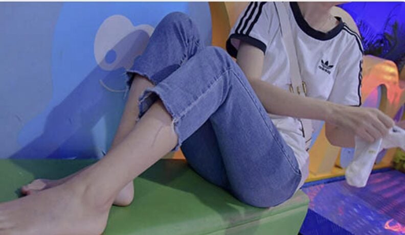 YJ Street Shot | The white socks feet of a part-time girl in a supermarket